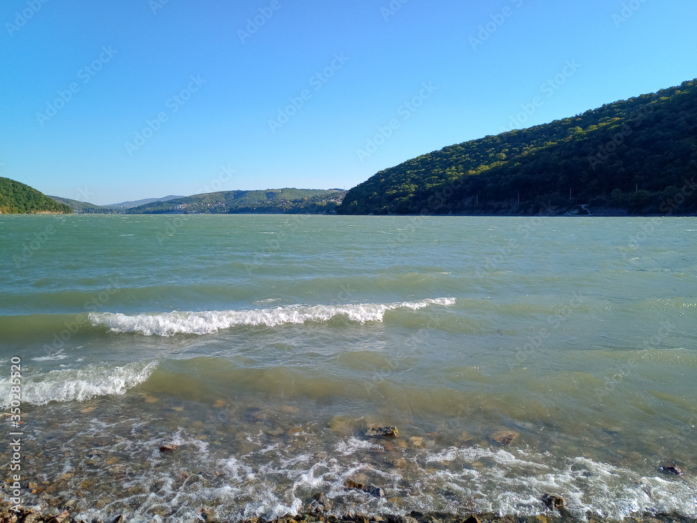 Shore and waves of lake abrau durso. Mountain lake in Caucasus.