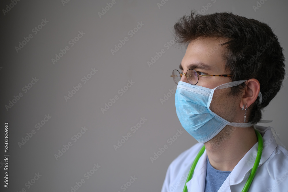 Portrait of the handsome young doctor. He is wears a medical mask Portrait of the handsome young doctor. He is wears a medical mask