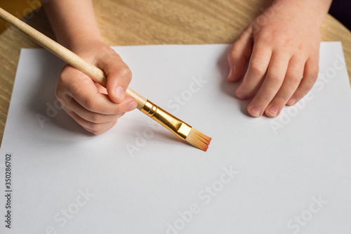children's hand with a brush on a white background