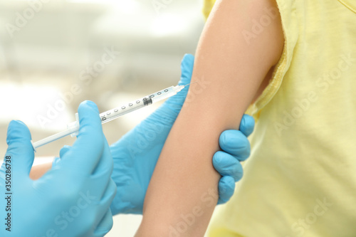 Doctor vaccinating little child in clinic  closeup