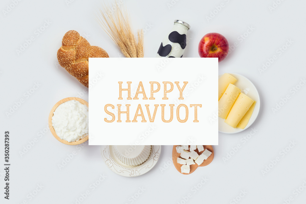 Plakat Jewish holiday Shavuot banner design with milk bottle, cheese and bread on white background. Top view from above