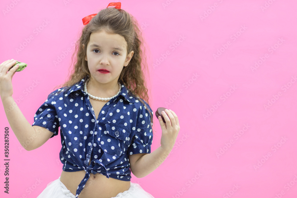 A girl holding two macaroons in hands.