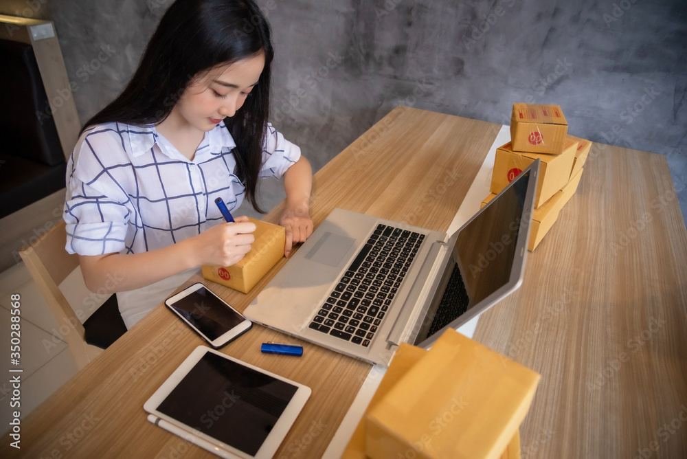 Portrait of Young asian working online shopping with laptop computer at home. Selling online and delivery concept Portrait of Young asian working online shopping with laptop computer at home. Selling online and delivery concept