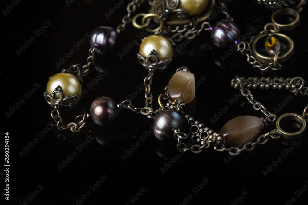 Jewelry on black glass. Semi-precious stones with antique chain Jewelry on black glass. Semi-precious stones with antique chain