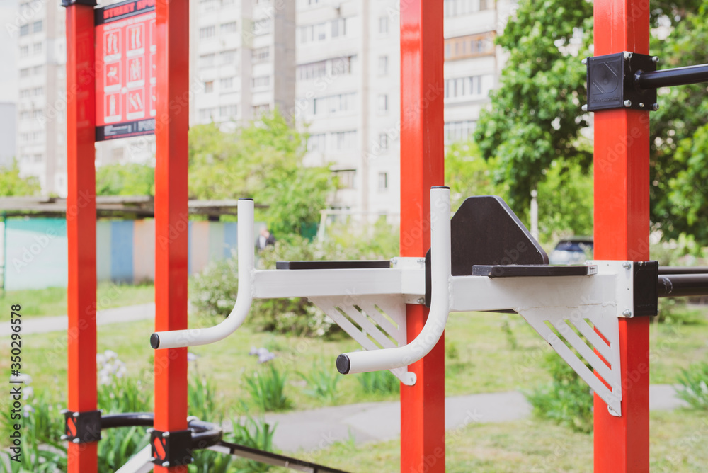 Closeup view of a multicolored monkey bar metal frame in summer sunny day. metal construction for pulling and climbing on the sports field Closeup view of a multicolored monkey bar metal frame in summer sunny day. metal construction for pulling and climbing on the sports field