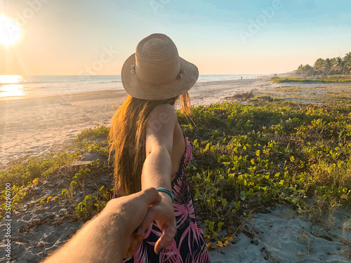 Tableau sur toile young man following his girlfriend on the beach