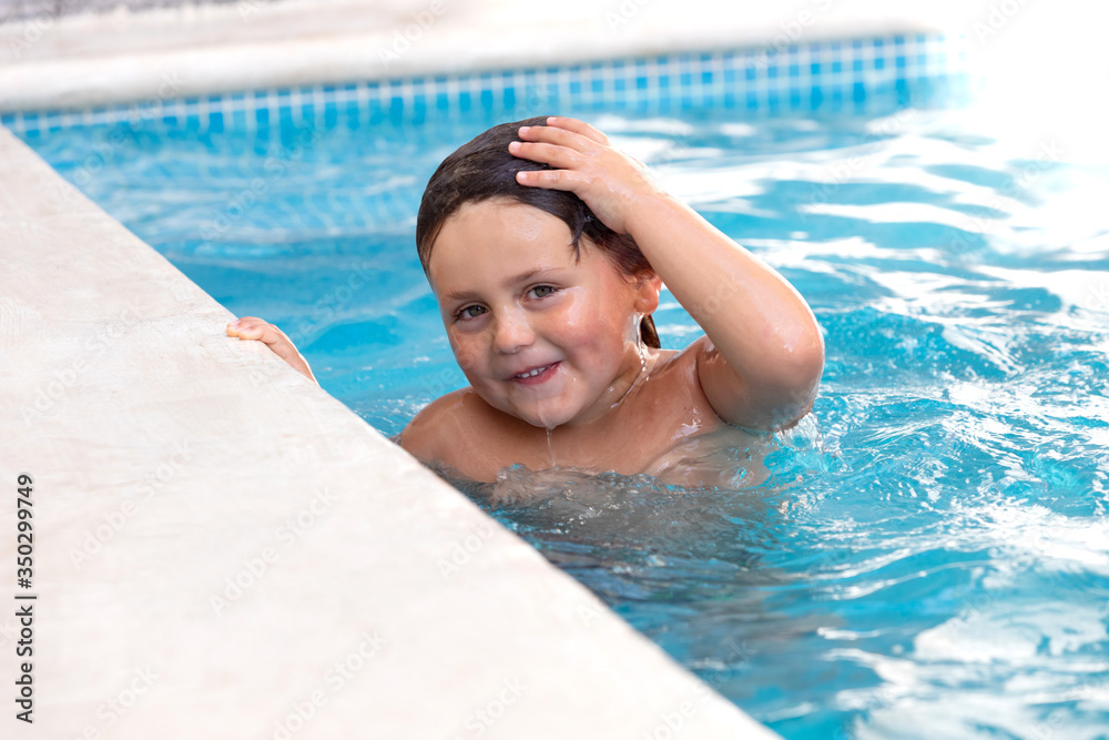 Little child splashing out in the pool