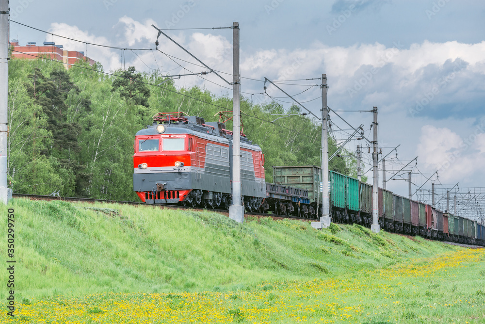 Freight train moves by the spring forest. Freight train moves by the spring forest.
