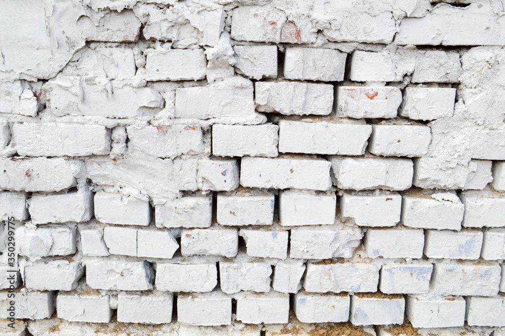 Beautiful white painted brick wall shabby old with cracks in the loft style with seams. Texture, background Beautiful white painted brick wall shabby old with cracks in the loft style with seams. Texture, background
