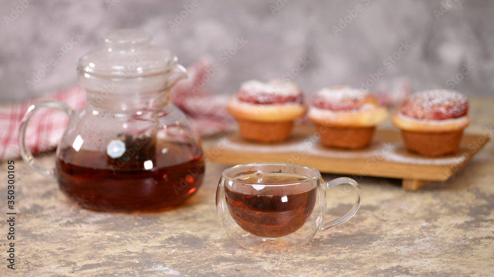 A cup of tea with roses buns, sweet buns with sugar powder. A cup of tea with roses buns, sweet buns with sugar powder.