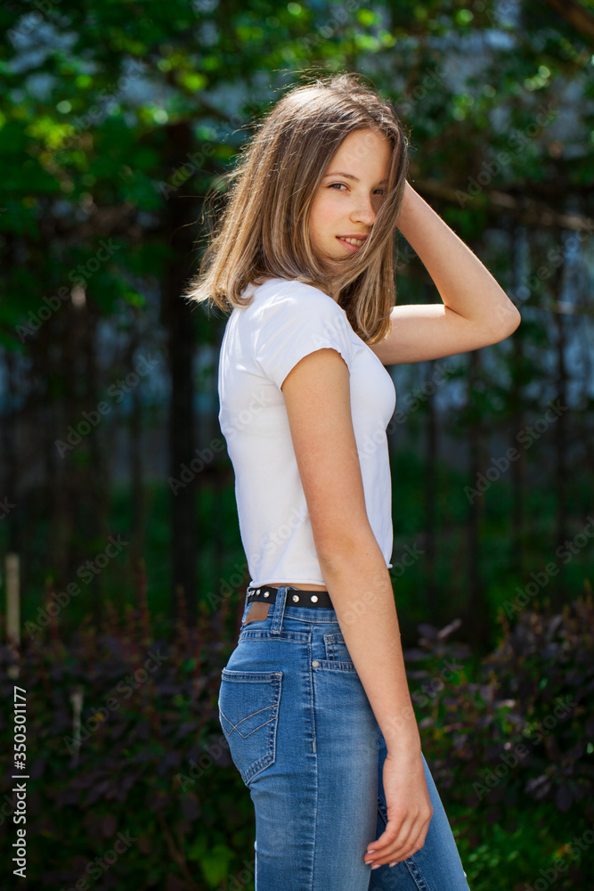 Portrait of a young blonde girl in white t-shirt and blue jeans Portrait of a young blonde girl in white t-shirt and blue jeans