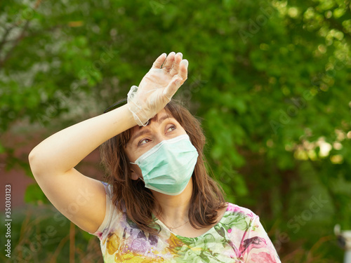 a woman in a medical mask for protection from coronavirus walks in the Park. close up.