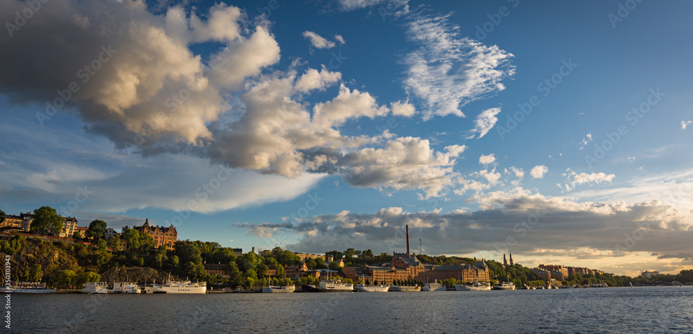 Panoramic sunset view of the Hogalid neighborhood in Stockholm. Sea horizon line and clouds in the sky.
