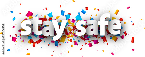 Stay safe sign over confetti background.