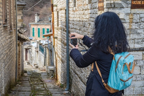 A young lady taking photos in the village of Dilofo one of the 46 traditional villages of Zagoroxoria in Pindos Epirus Greece photo