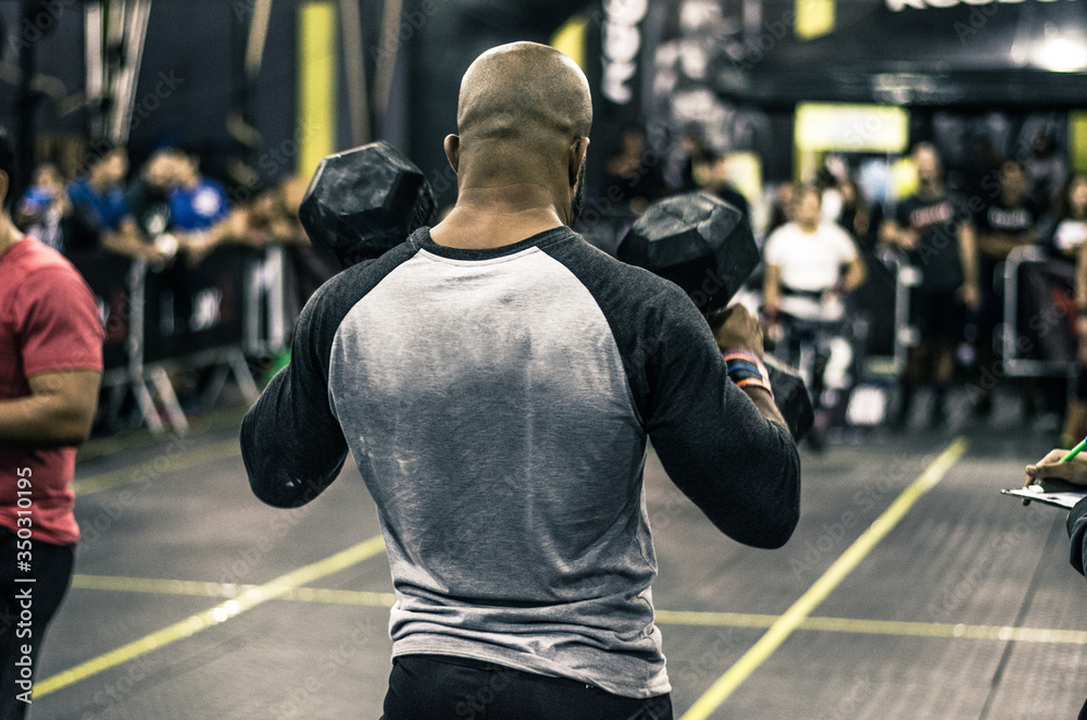 Sport. Muscular african man lifting weights in a gym.