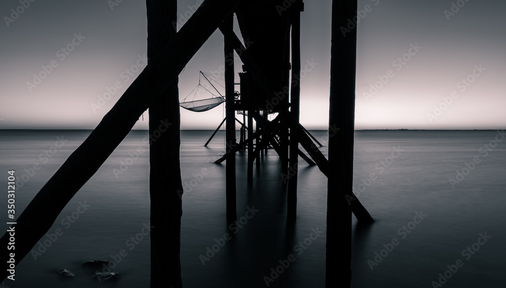 from behind view of a fishing hut on stilts called Carrelet. black and white and long exposure photography from behind view of a fishing hut on stilts called Carrelet. black and white and long exposure photography