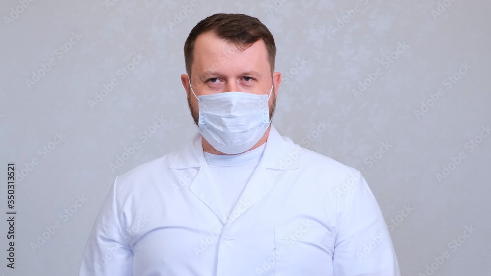 man in a protective mask and a white shirt looks at the camera, close-up. Hygiene concept. prevent the spread of germs and bacteria and avoid infection with the crown virus. copy space man in a protective mask and a white shirt looks at the camera, close-up. Hygiene concept. prevent the spread of germs and bacteria and avoid infection with the crown virus. copy space