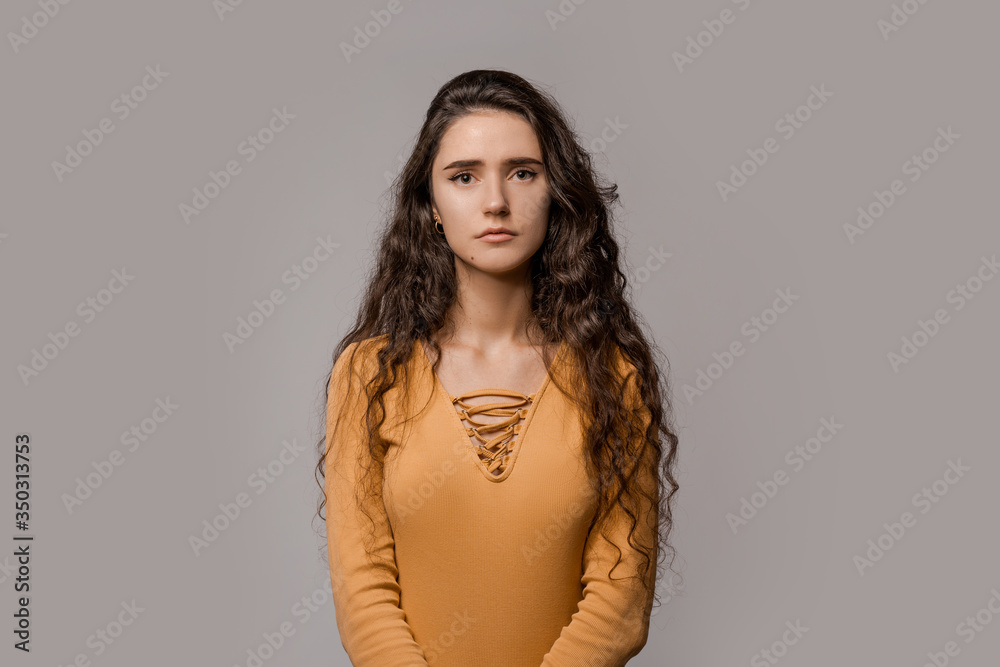 Sad offended young beautiful woman feels humiliated, moral abuse concept. People emotions, problems with communication. Over grey studio background Sad offended young beautiful woman feels humiliated, moral abuse concept. People emotions, problems with communication. Over grey studio background