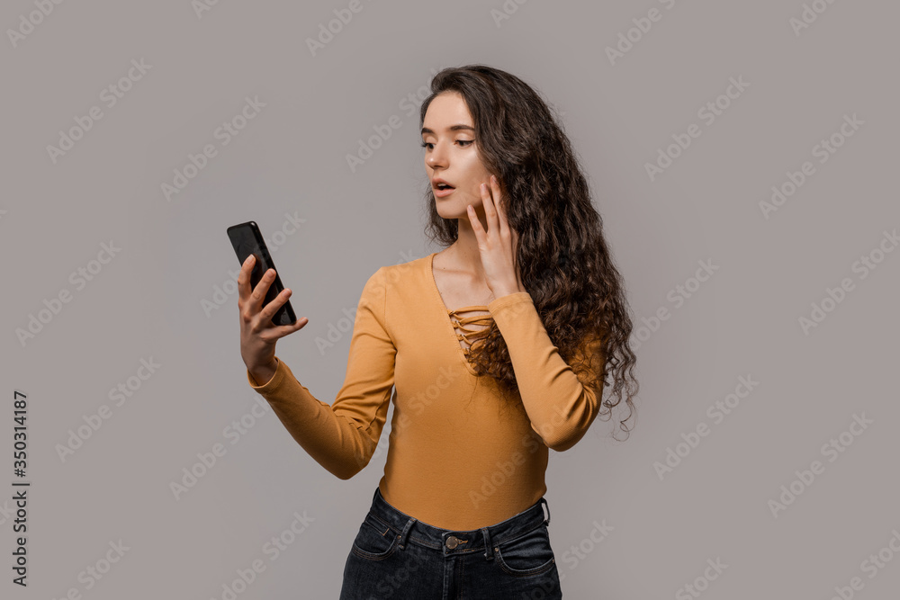 Chatting on mobile cell phone, online internet technology concept. 5g connecting and communication. Shocked face of beautiful woman in yellow, amazed news, wow effect on face. People expressions Chatting on mobile cell phone, online internet technology concept. 5g connecting and communication. Shocked face of beautiful woman in yellow, amazed news, wow effect on face. People expressions