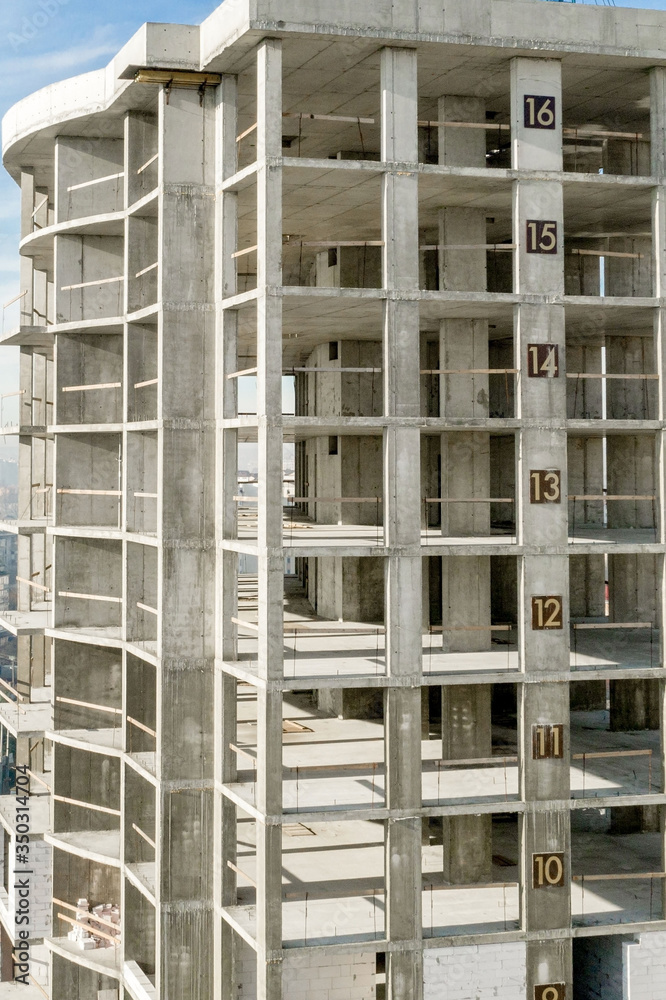 Aerial view of concrete frame of tall apartment building under construction in a city Aerial view of concrete frame of tall apartment building under construction in a city
