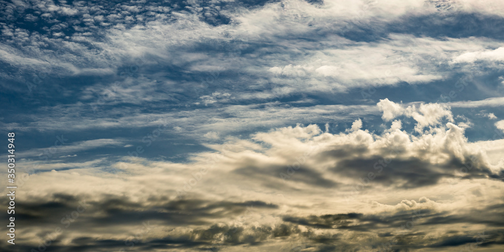 Large panoramic view of dramatic sky with clouds illuminated by warm light. atristic picture for creative design or decoration