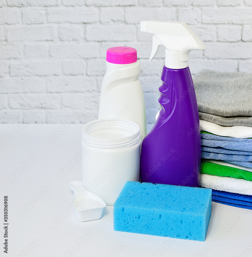 Laundry detergents: detergent, washing powder and a stack of clean clothes on on a white background. Copy space. The concept of cleanliness. Laundry detergents: detergent, washing powder and a stack of clean clothes on on a white background. Copy space. The concept of cleanliness.