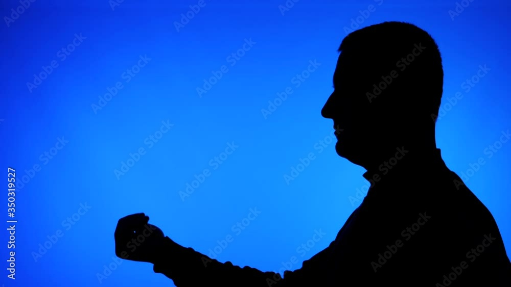 Silhouette of adult male on a blue background showing come here sign. Showing the gesture from a side view. Silhouette of adult male on a blue background showing come here sign. Showing the gesture from a side view.