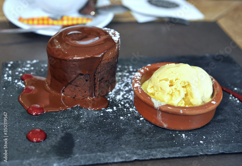 Chocolate fondant and vanilla ice cream in cafe. Delicious dessert in style. Sweet lifestyle. photo