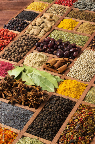 Fototapeta Naklejka Na Ścianę i Meble -  Indian spices and herbs in wooden box. Collection of various condiments for design of package with food. Seasoning background