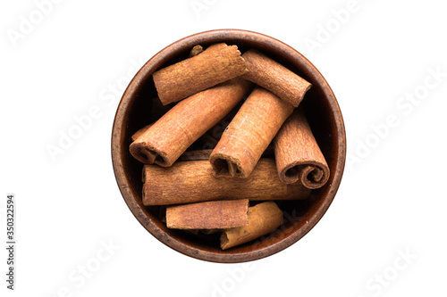 Fototapeta Naklejka Na Ścianę i Meble -  cinnamon sticks spice in wooden bowl, isolated on white background. Seasoning top view