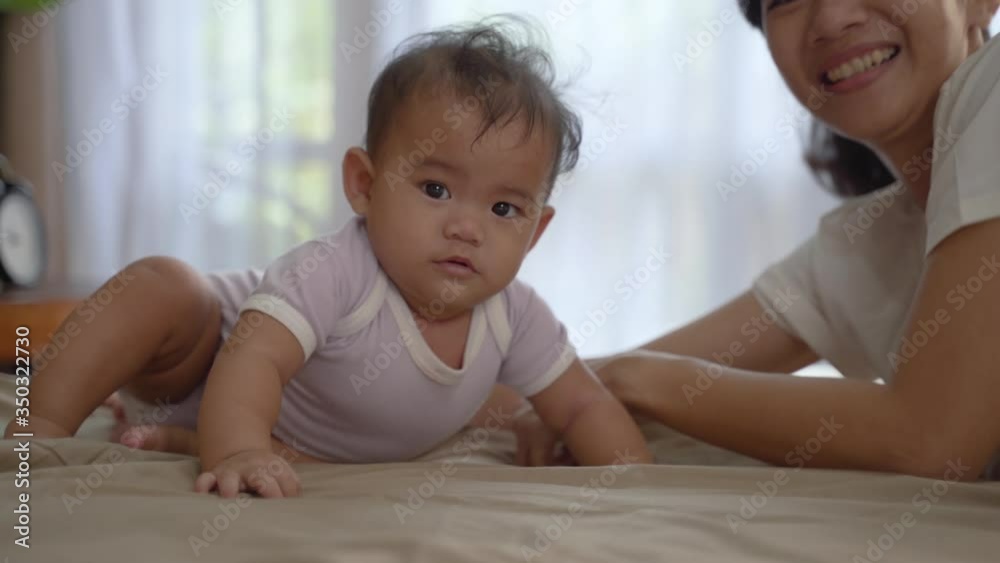 beautiful happy mother playing with her baby on the bed beautiful happy mother playing with her baby on the bed