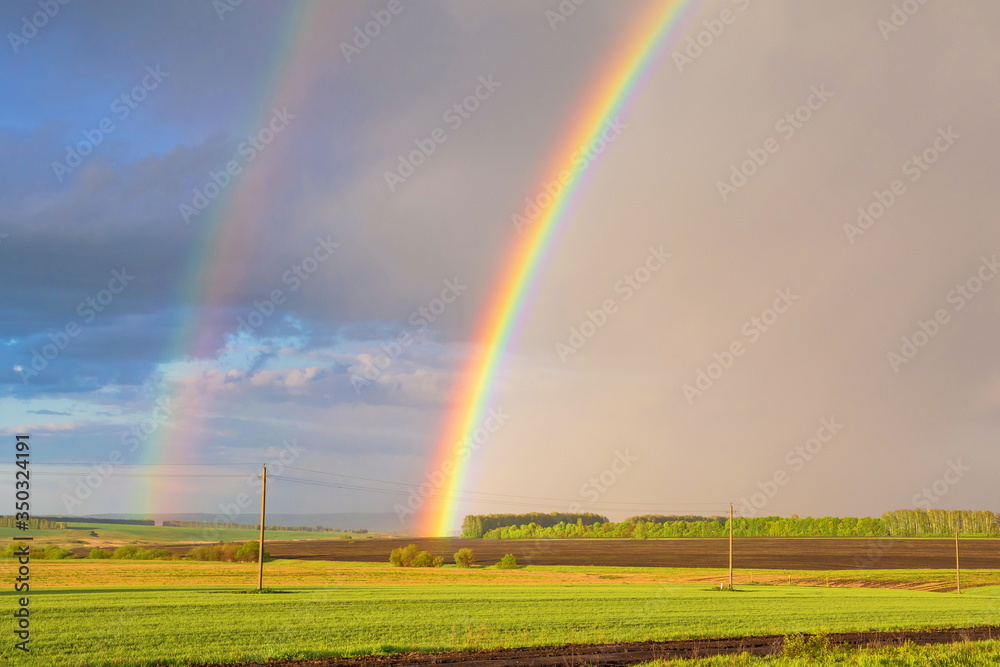 Double rainbow over the field after rain Double rainbow over the field after rain