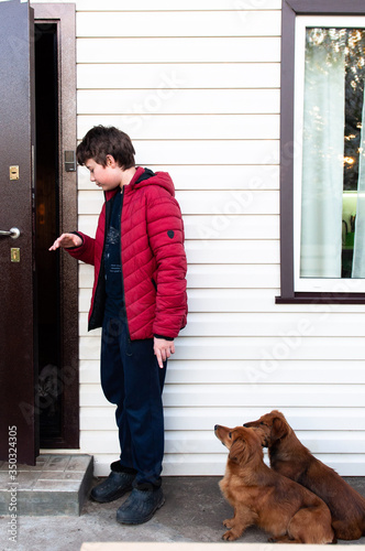 boy and dog near the door of the house
