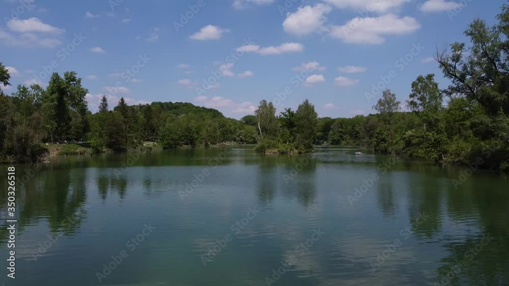 drone shot over lake with green trees and blue sky drone shot over lake with green trees and blue sky