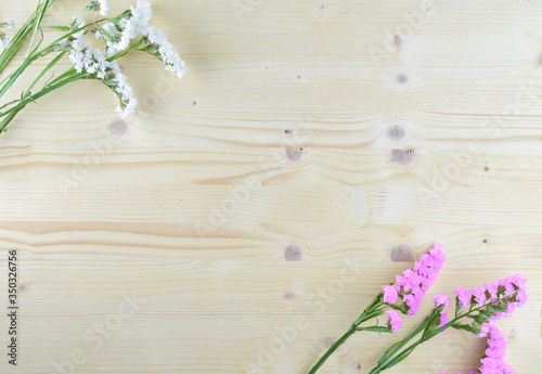 white and purple flowers on wooden background in aerial shot with copyspace