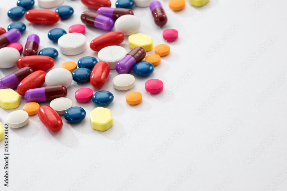 Close up view of different colors pills on white back Close up view of different colors pills on white back