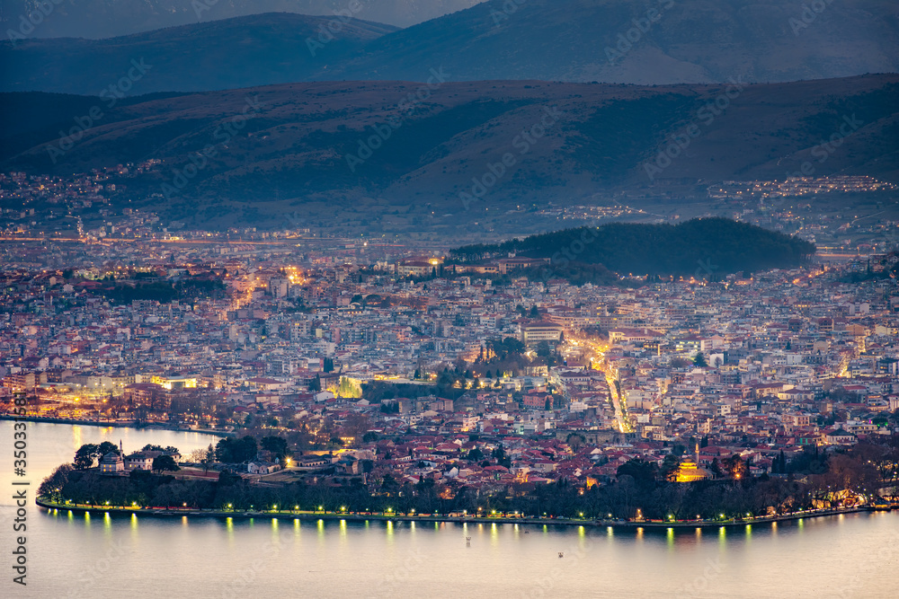 Aerial view of the city of Ioannina and its lights reflecting in the lake during sunset in Epirus Greece