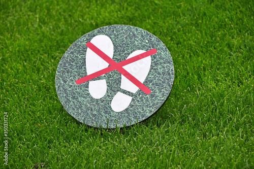 Valokuva Keep off the grass warning sign over green lawn