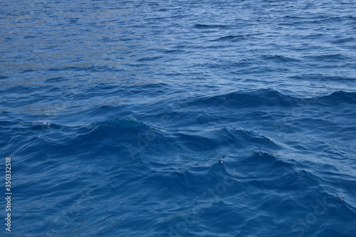 Blue sea water surface with ripples and waves