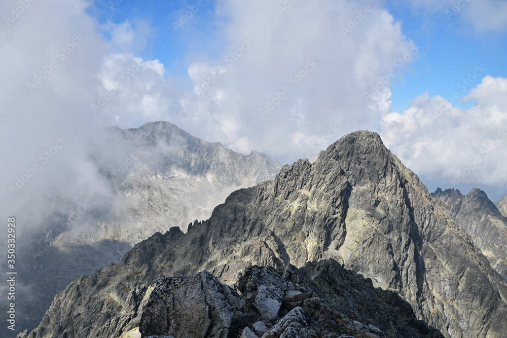 Rocky mountain ridge in foggy clouds