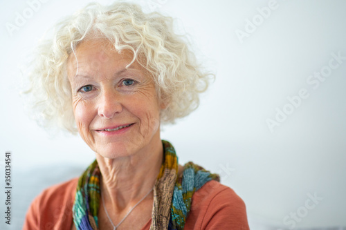 Close up attractive old woman smiling against white background
