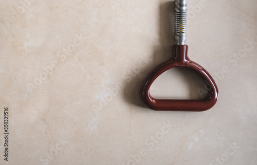Flat lay image of a metro train passenger handle support strap on a marble background. Daily office commute and tube travel concept with empty copy space for text.