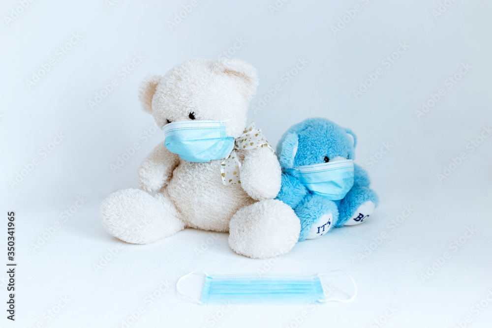 several soft toys in a medical mask on a white background