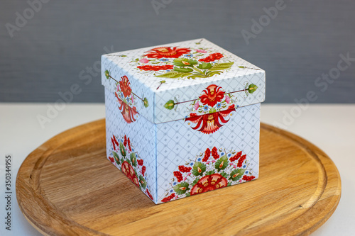 Petrikov painting, gift box on a wooden stand photo