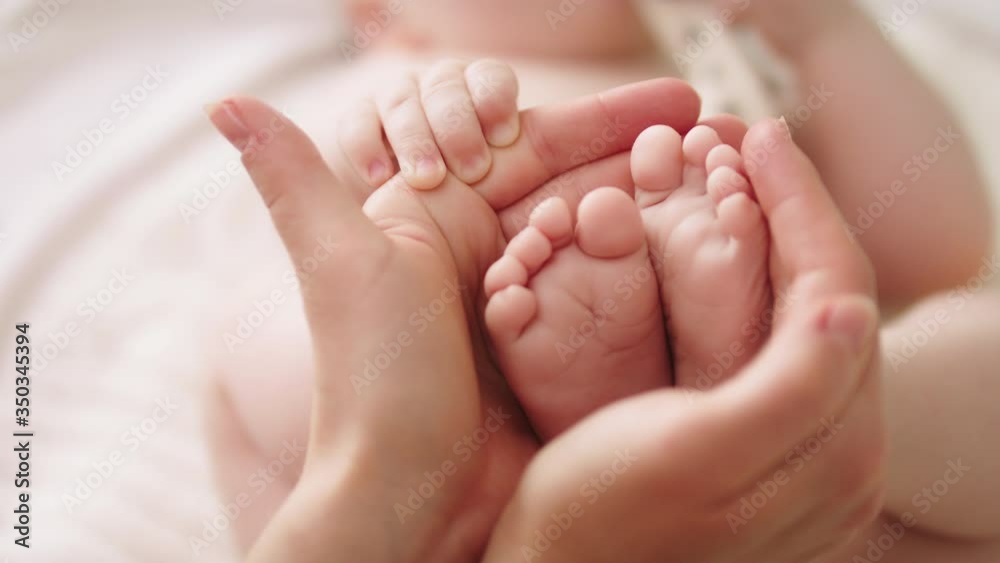 Baby feet in mothers hands. Close up. Happy Family concept. Baby feet in mothers hands. Close up. Happy Family concept.