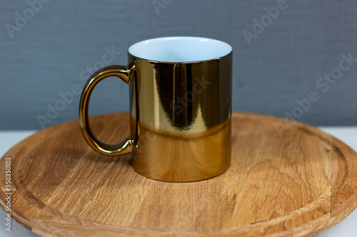 gold sublimation cup on a wooden stand, chrome mug