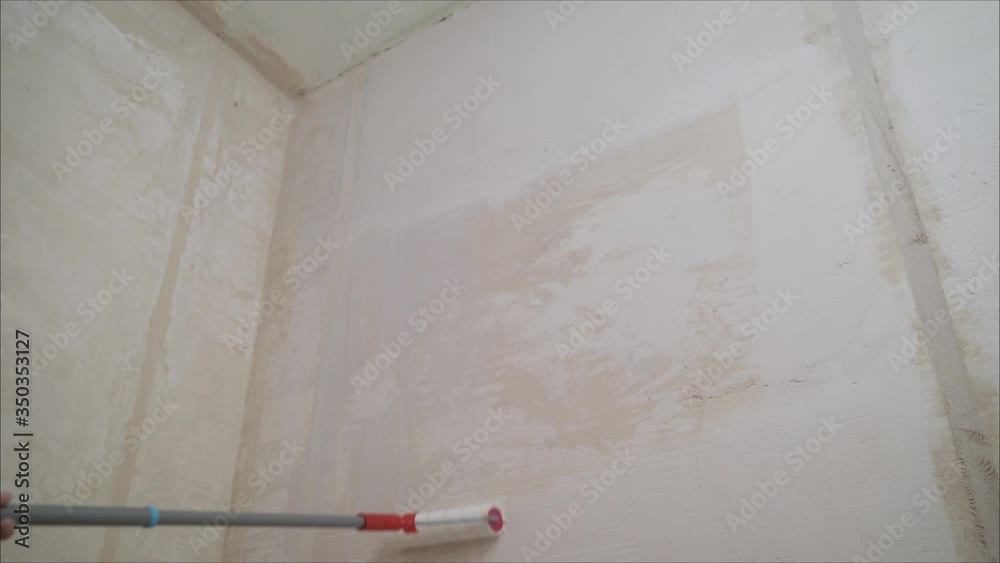 Stucco walls with a building roller. Closeup hand holds rolling paint