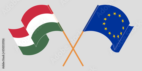 Crossed and waving flags of Hungary and the EU
