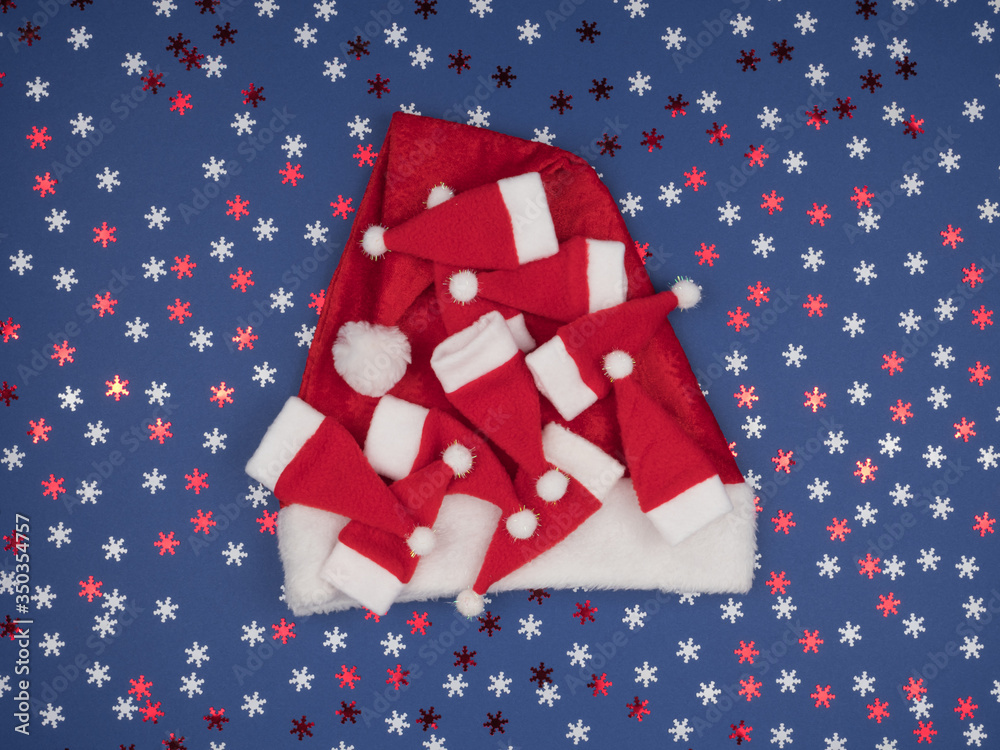 Obraz premium Santa Hat. Many small caps Santa. Blue background.